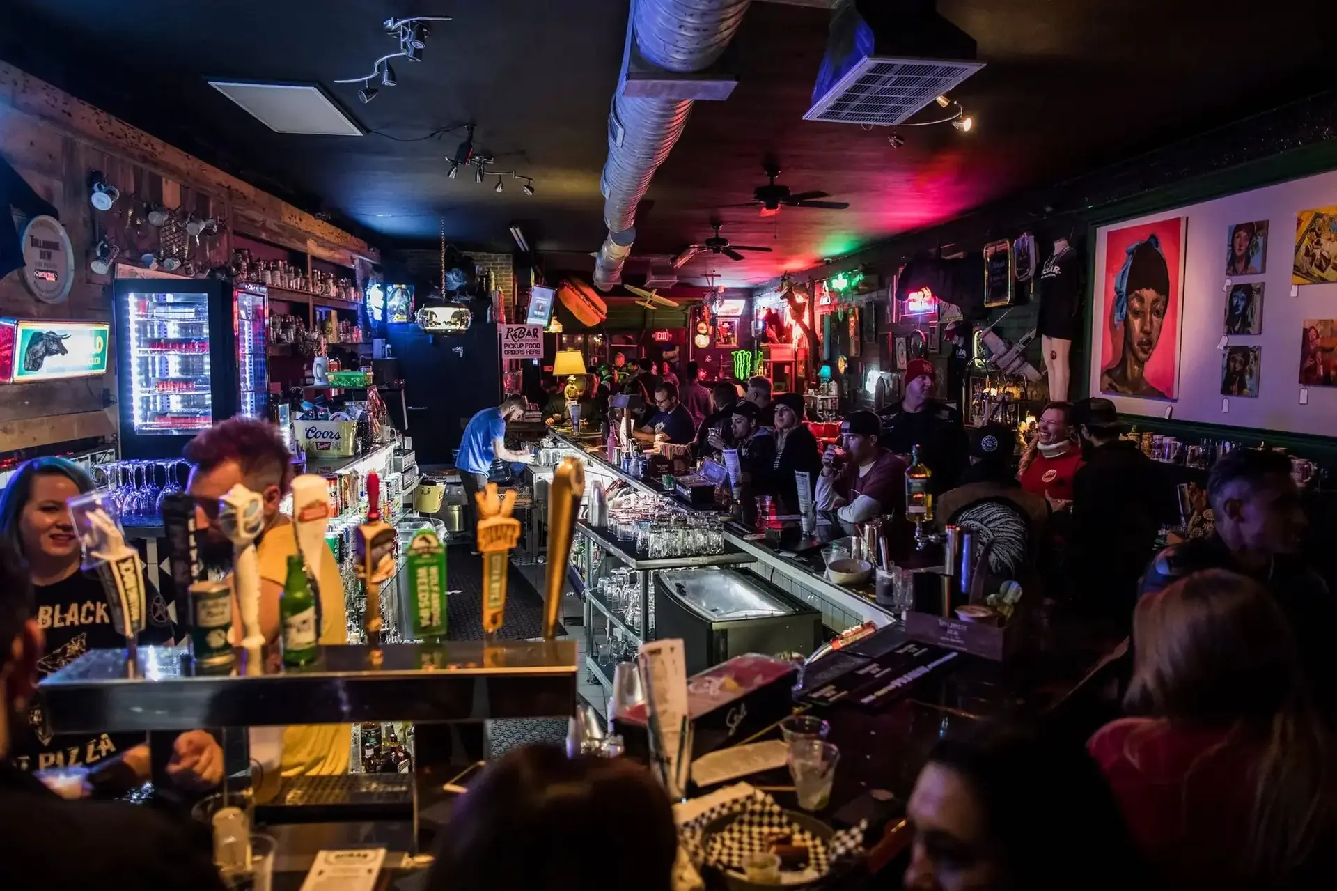A bartender working behind ReBAR's busy front bar.