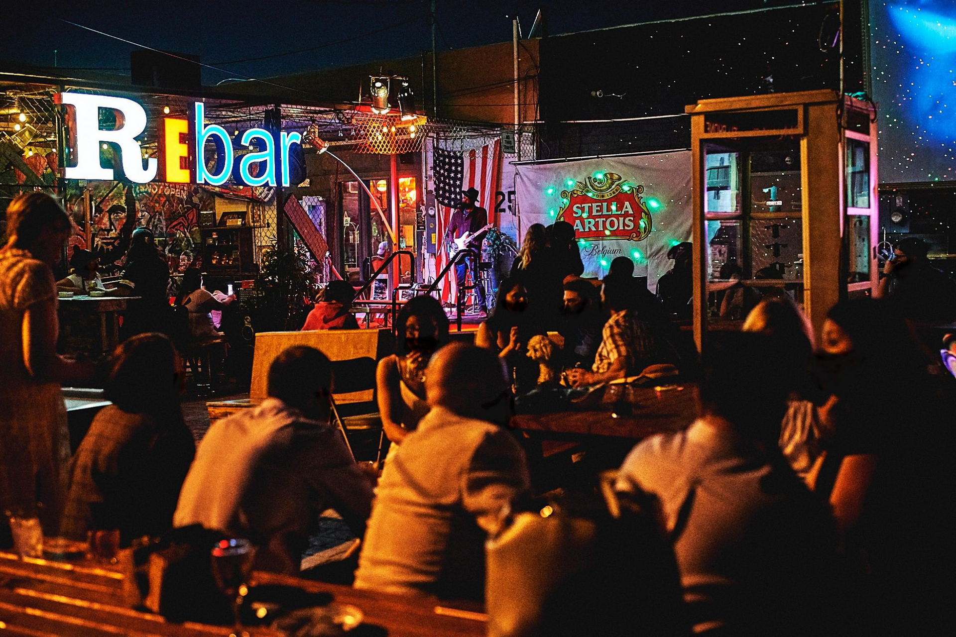Tables on ReBAR's patio at night.